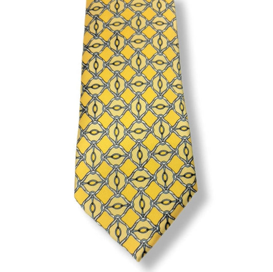 A yellow necktie with a repeating geometric pattern of interlocking diamond and oval motifs outlined in dark gray and black, shown against a plain white background.
