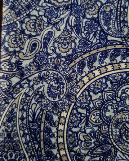 A close-up of a fabric or wallpaper pattern featuring an intricate navy blue and gray paisley and floral design.