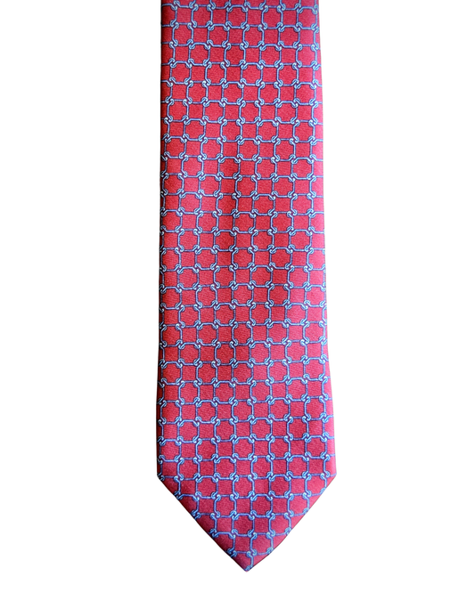 A red necktie with a repeating blue geometric lattice pattern, shown flat against a plain white background.