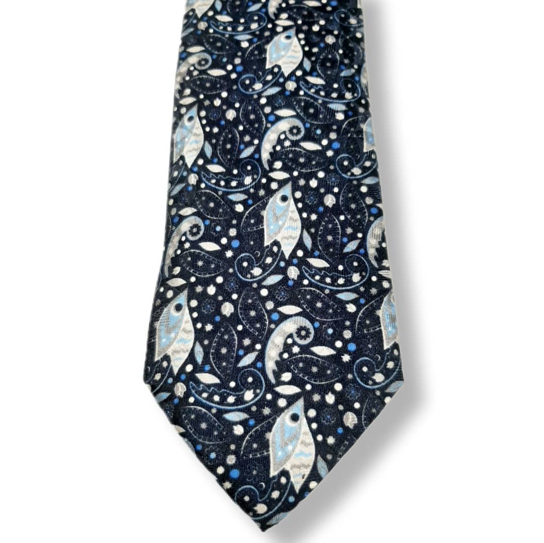 A necktie with a dark navy blue background featuring a detailed pattern of stylized fish, paisley swirls, and small stars in light blue, white, and silver.