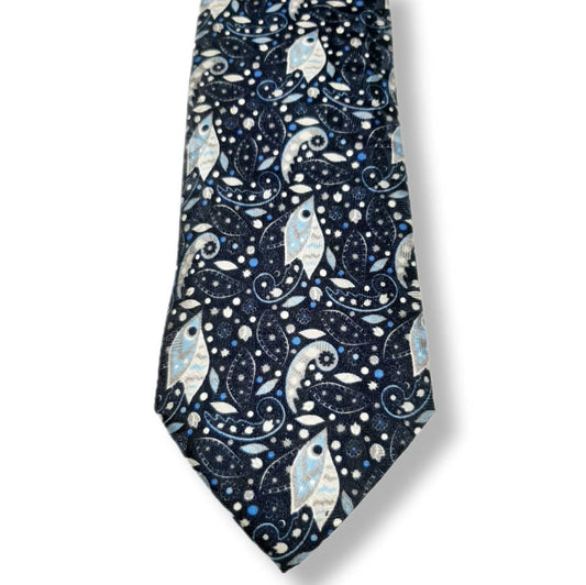 A necktie with a dark navy blue background featuring a detailed pattern of stylized fish, paisley swirls, and small stars in light blue, white, and silver.
