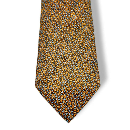 A necktie with an all-over abstract pattern of small teardrop-like shapes in orange, blue, and white on a dark background, shown against a plain white background.