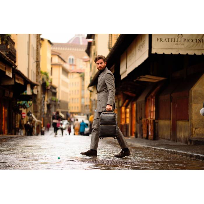 Man in a suit walking down a city street holding a briefcase