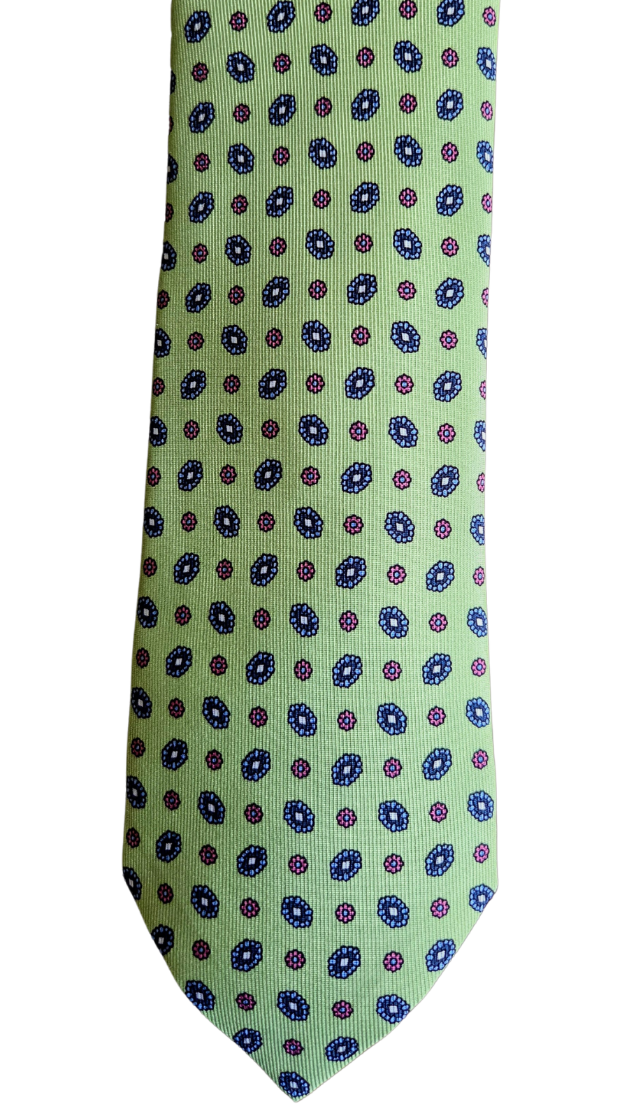 A slim necktie with a light sage green base, featuring a repeating pattern of small blue and purple circular medallions, shown against a plain white background.